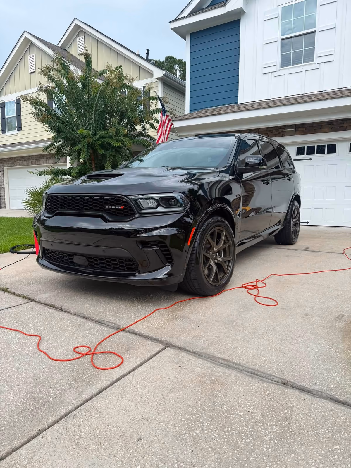 Black Dodge SUV from KD’s on-location vehicle work in a residential driveway